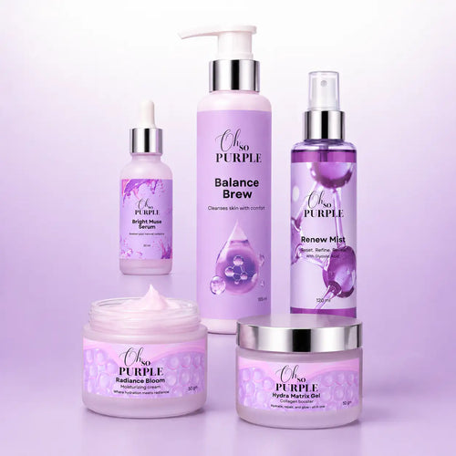A set of five Oh so Purple skincare products arranged together on a light lavender background, including a pump bottle of Balance Brew, a dropper bottle of Origin Glow Serum, a spray bottle of Renew Mist, a jar of Radiance Bloom cream, and a jar of Hyalunder Gel.